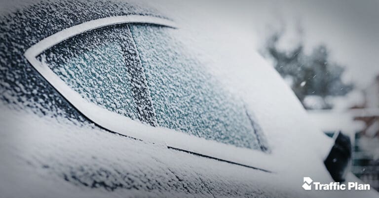 window of snow covered vehicle with traffic plan logo in bottom right corner