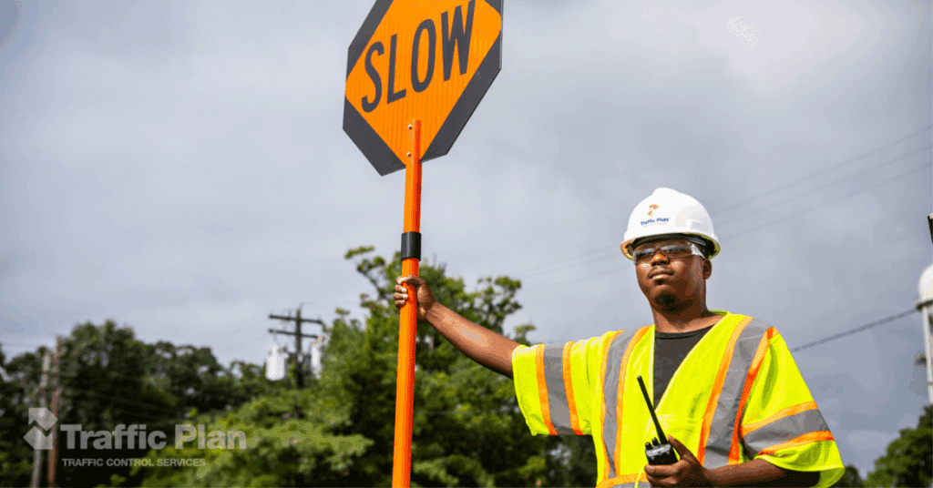 employee holding sign beneath grey sky
