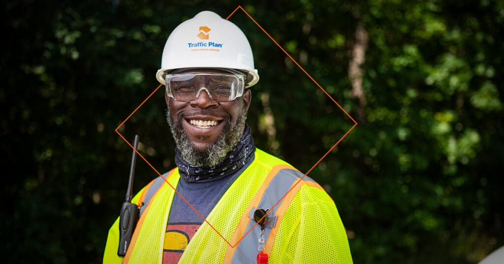 traffic plan employee smiling while wearing company branded hard hat and vest